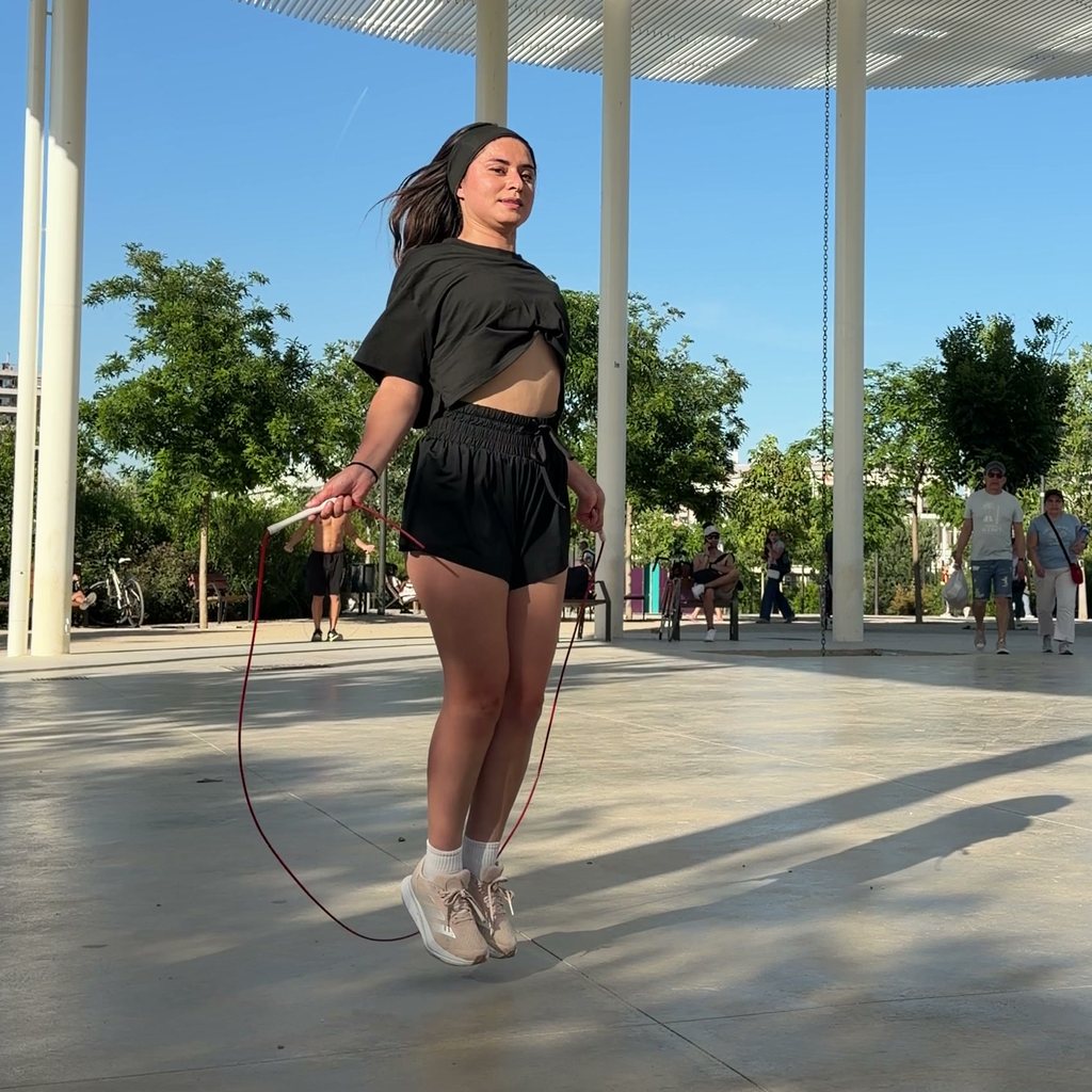 Une élève en plein saut sous un préau, la corde passe sous ses pieds