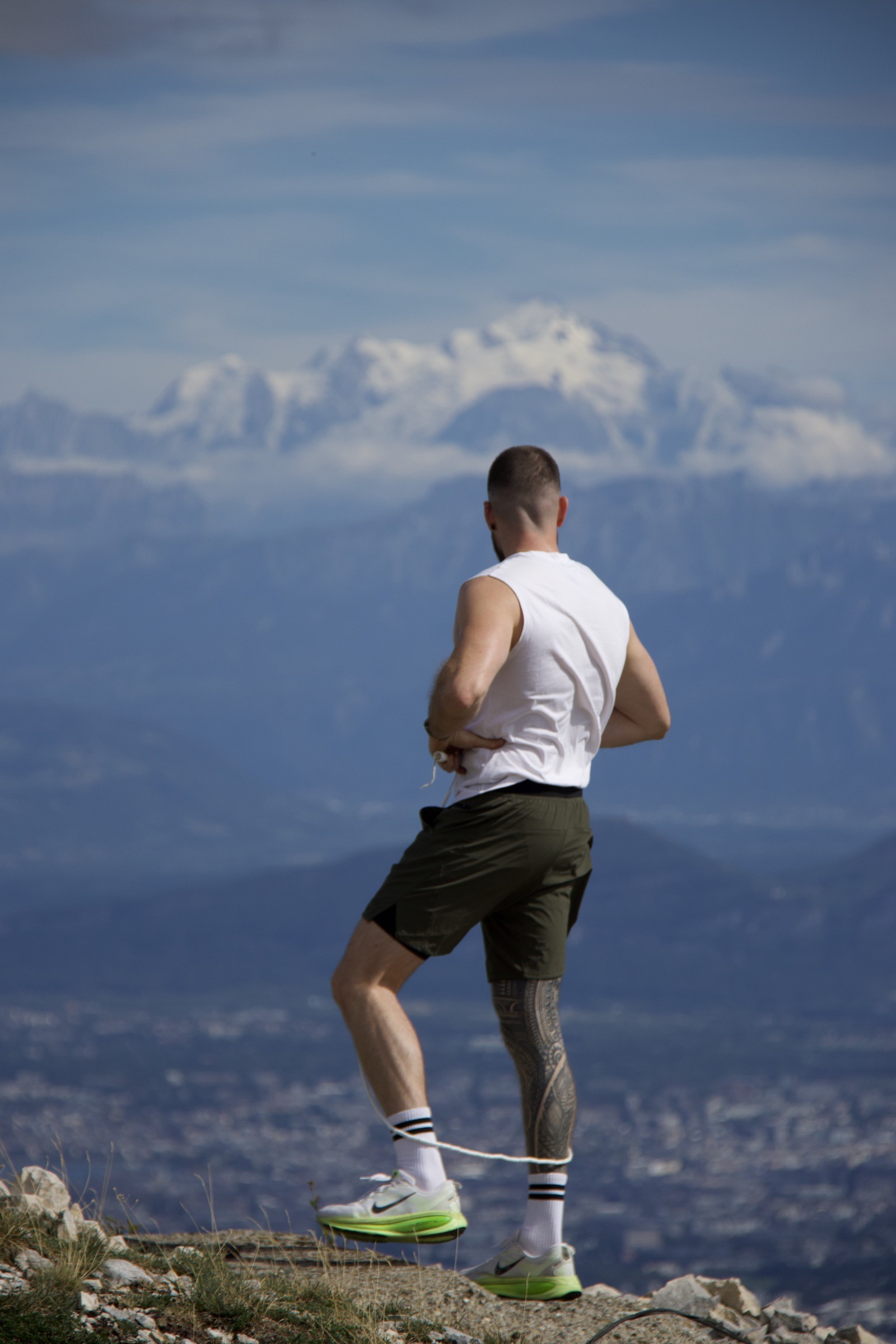 Kilian de dos saute à la corde sur une crête, face à la vallée